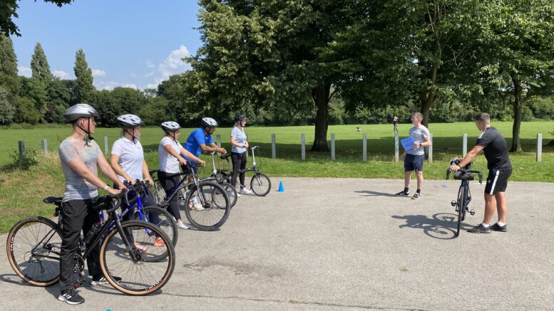 A group of people taking part in an adult cycle training session