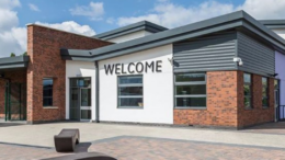 The outside of Bridgeview Special School. The building is white and brick and the letters on the outside say welcome.