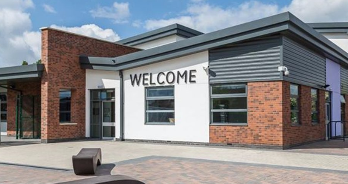 The outside of Bridgeview Special School. The building is white and brick and the letters on the outside say welcome.