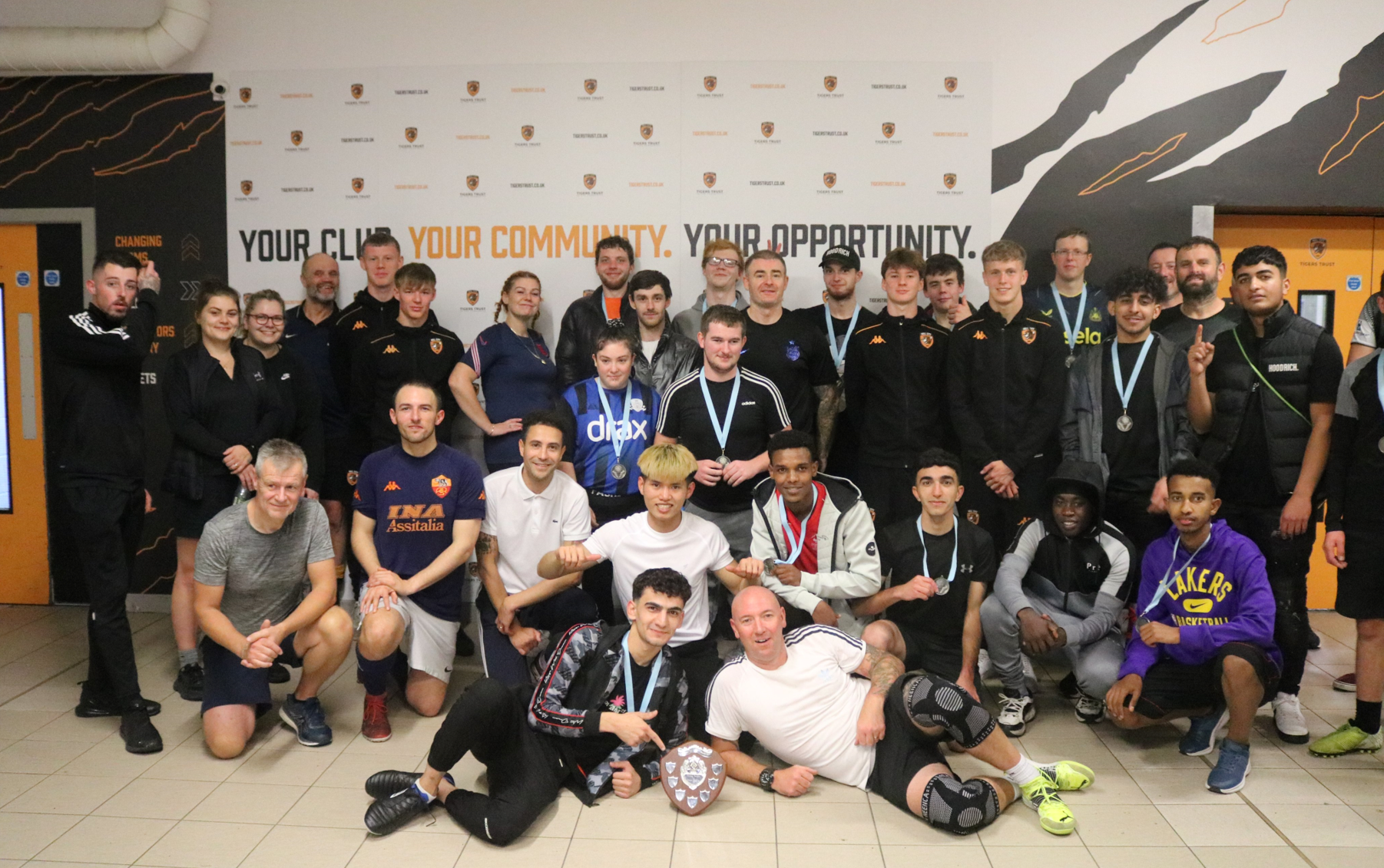People smiling wearing medals as they pose in a group photo.