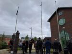 People gather to witness the flag of Srebrenica being raised outside the Guildhall to mark Srebrenica Memorial Day in 2024