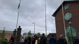 People gather to witness the flag of Srebrenica being raised outside the Guildhall to mark Srebrenica Memorial Day in 2024