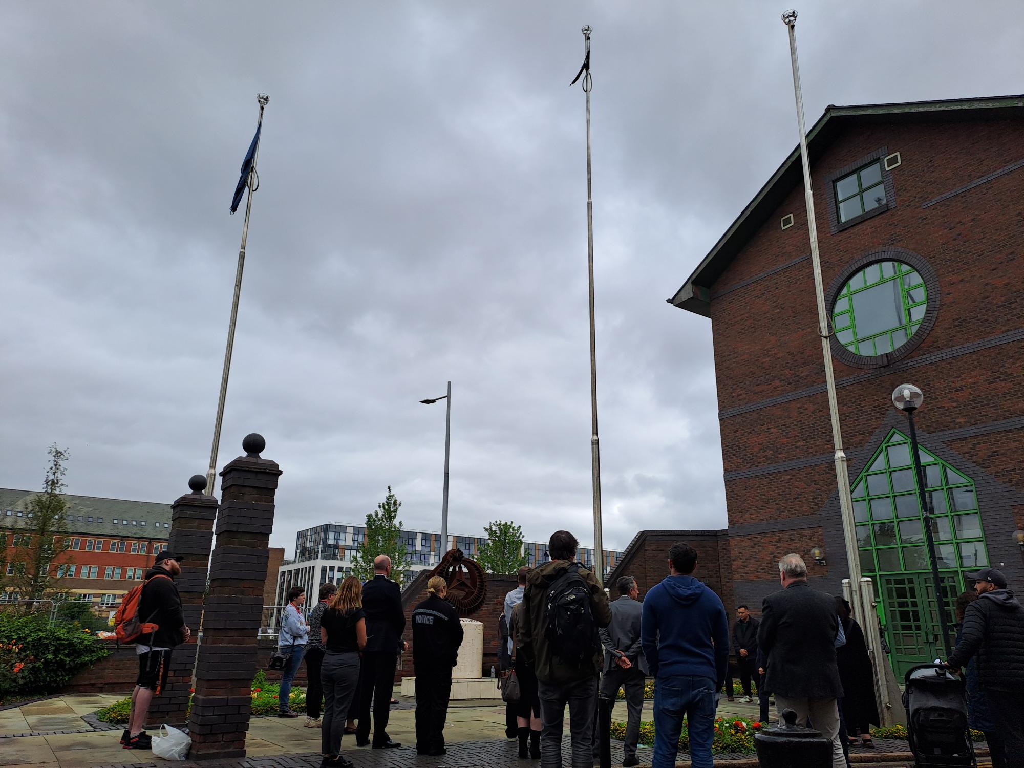 People gather to witness the flag of Srebrenica being raised outside the Guildhall to mark Srebrenica Memorial Day in 2024