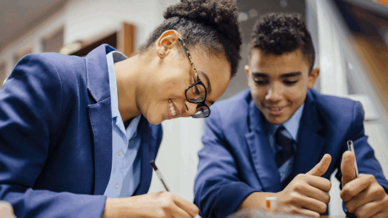 Students writing on a notepad in a classroom