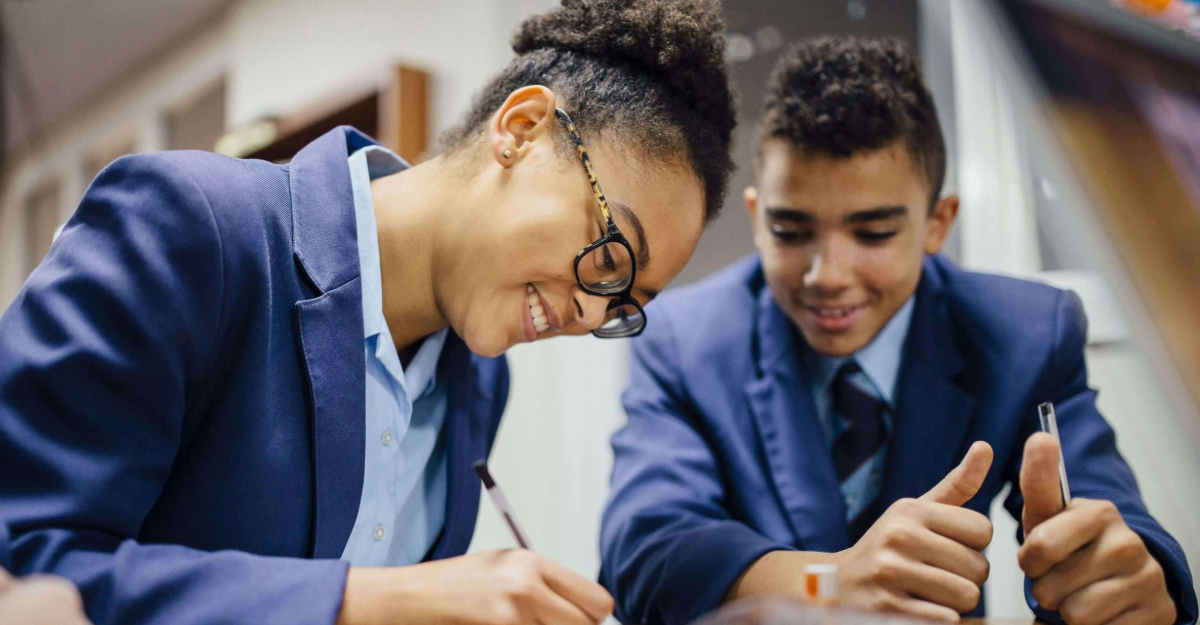 Students writing on a notepad in a classroom