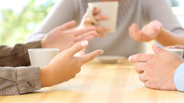 Three friends hands talking in a bar