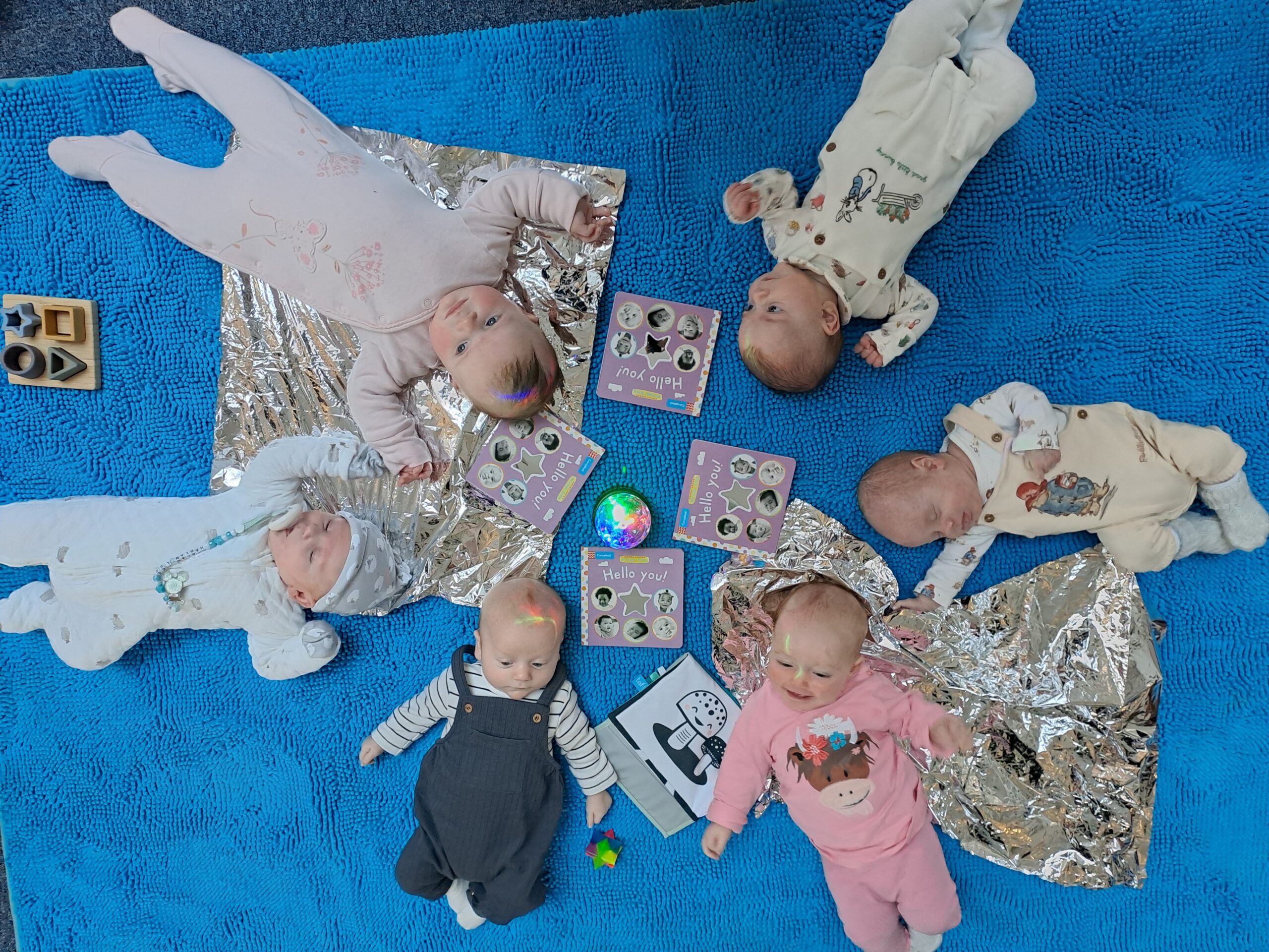 Six babies laid in a circle