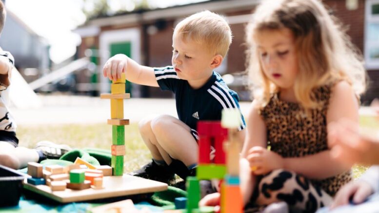 Boy and girl build towers outside