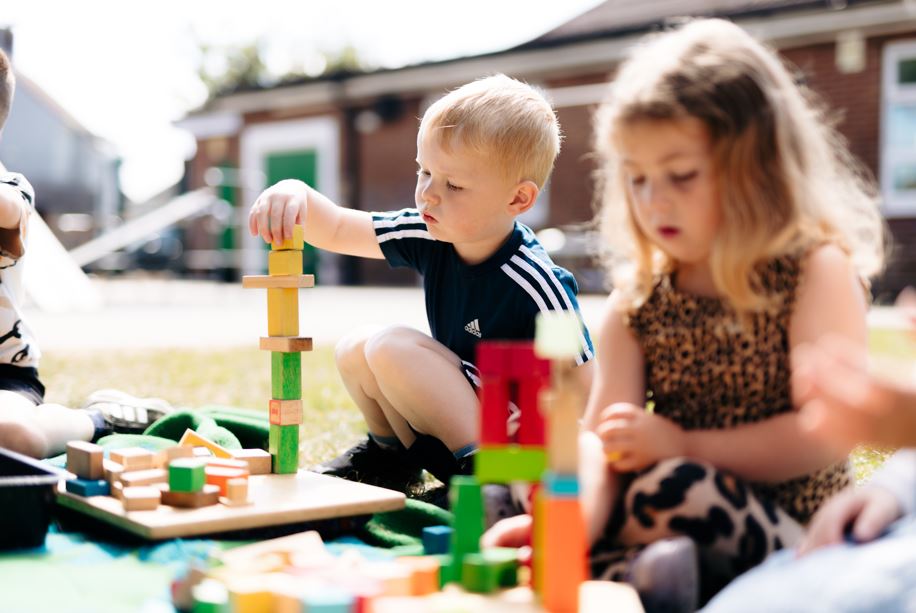 Boy and girl build towers outside