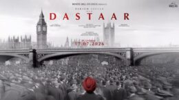 A black and white poster depicting London bridge and Bog Ben, with hundred of people facing away and one man at the forefront of the image in a red turban