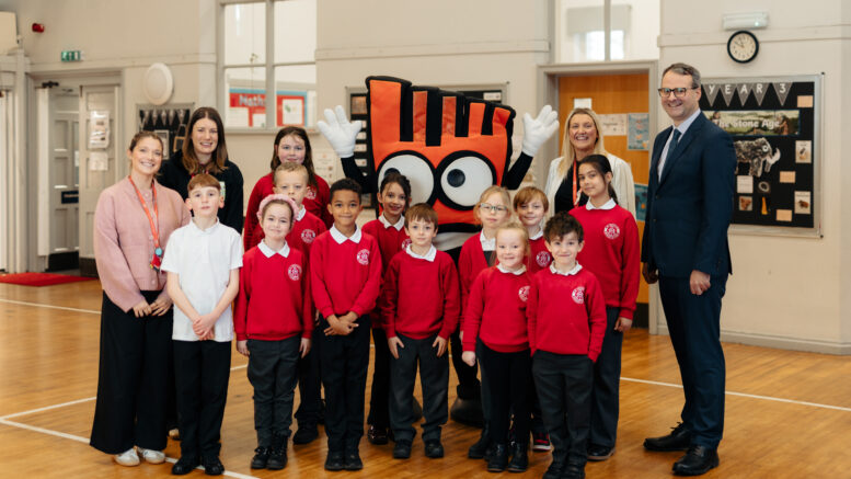 Staff and children at St Nicholas Primary School welcome Living Streets mascot, Strider, during their launch assembly for the Living Streets WOW Challenge