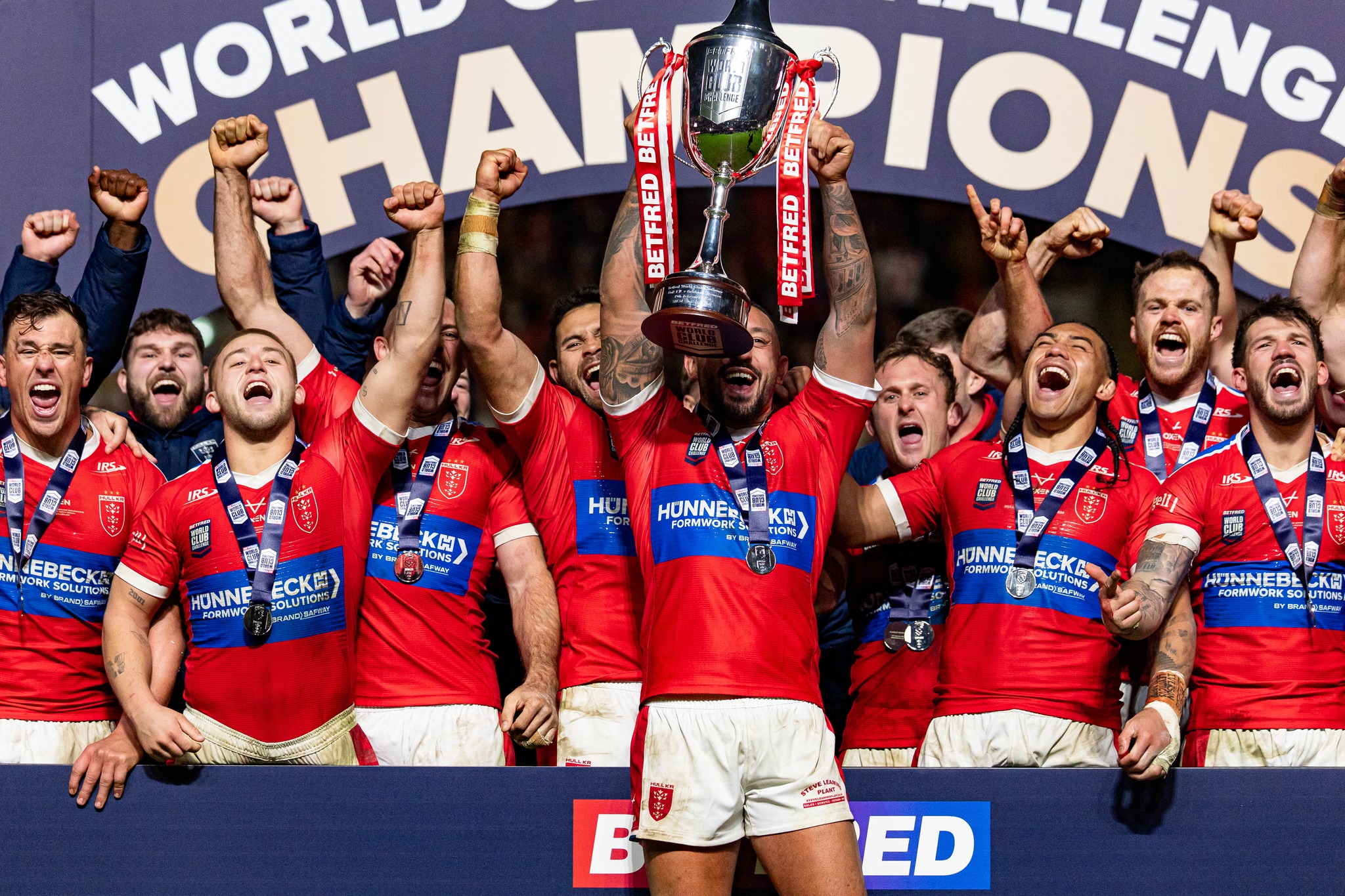Picture by Alex Whitehead/SWpix.com - 19/02/2026 - Rugby League - Betfred World Club Challenge - Hull KR v Brisbane Broncos - MKM Stadium, Hull, England - Hull KR captain Elliot Minchella lifts the trophy alongside his team-mates.