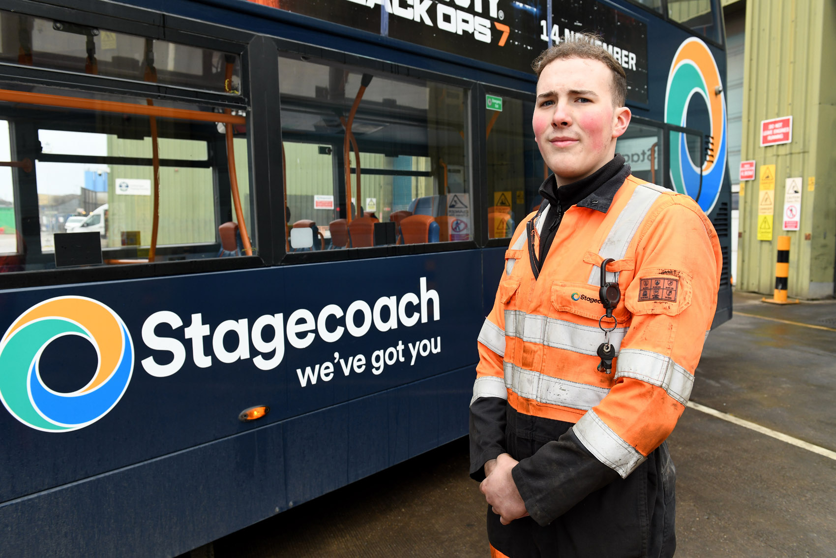 A photo of Stagecoach East Midlands apprentice, Adam Flowers, in front of a Stagecoach branded bus.