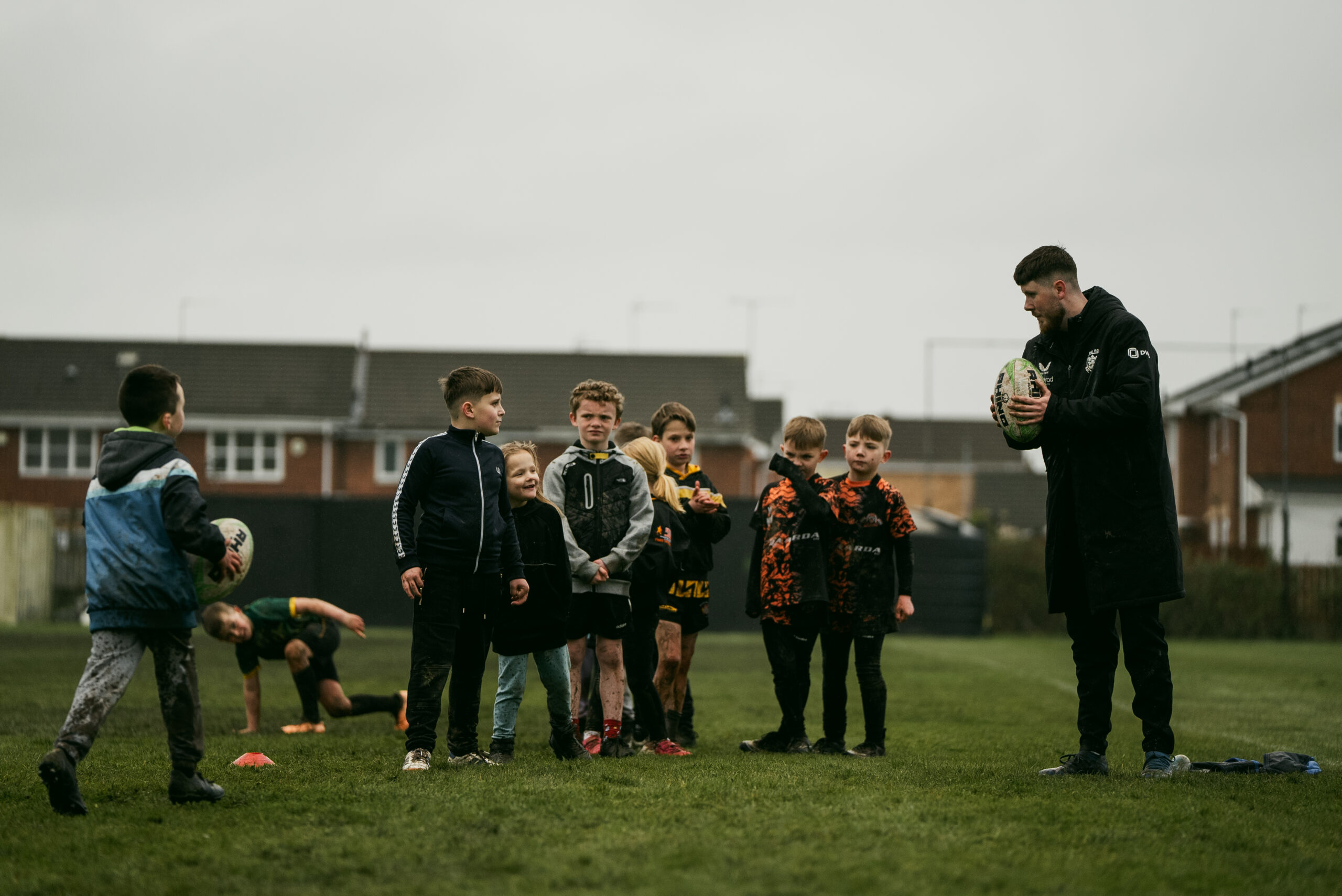 Children on a football field with a teacher