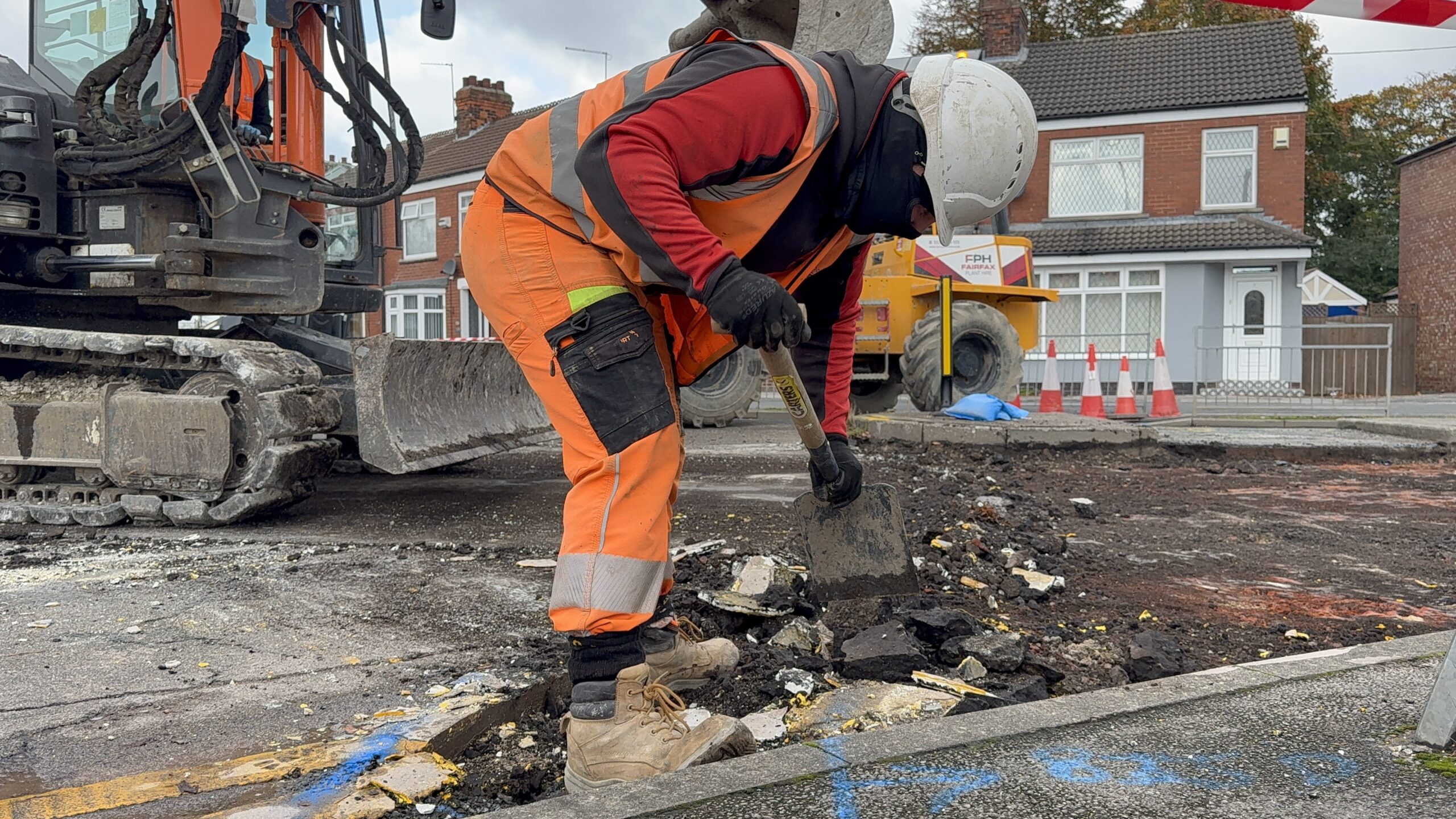 A highway worker resurfacing James Reckitt Avenue.