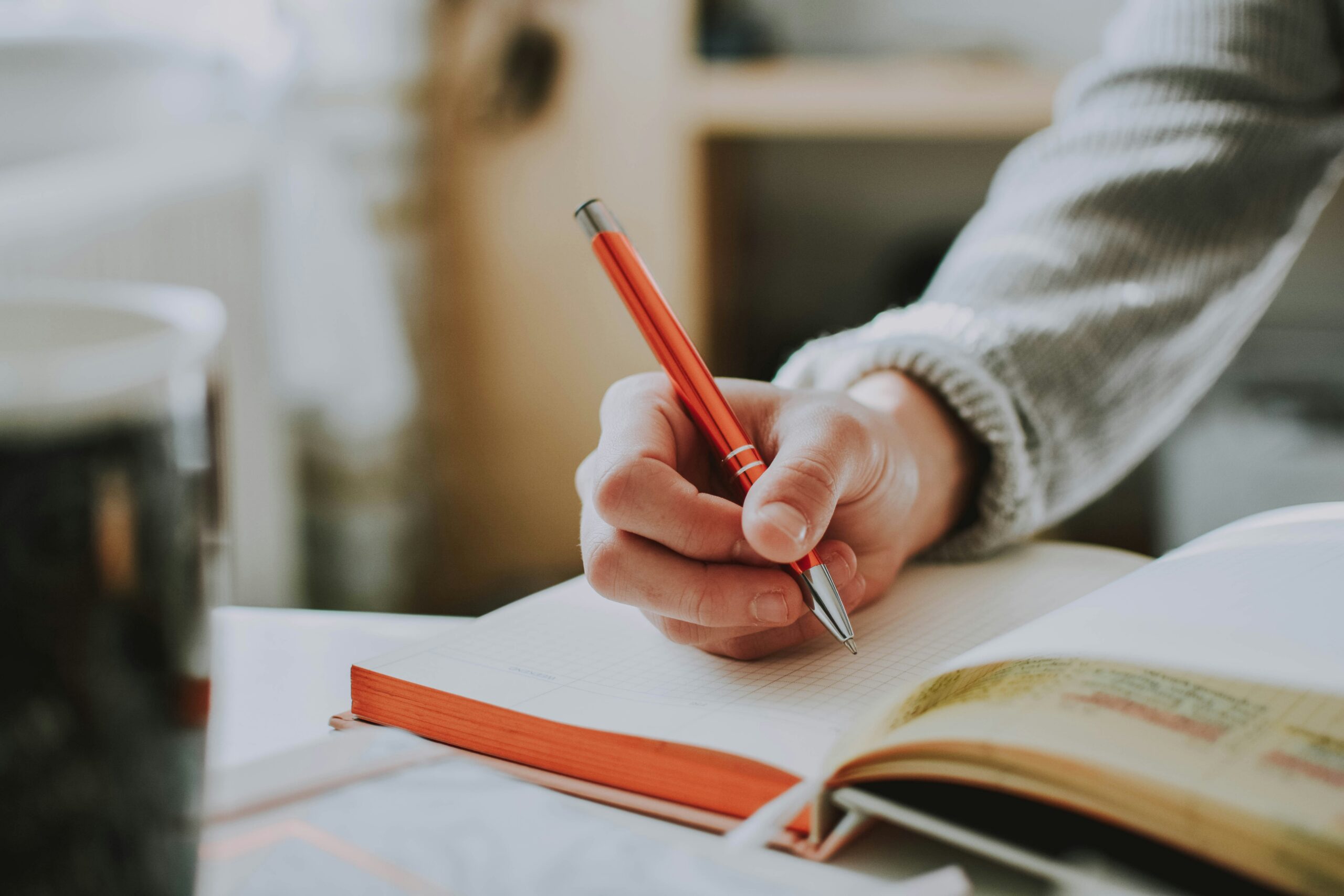 A person writes in a notebook