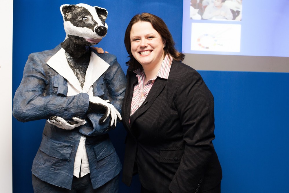 Ruth Badger stood with a six foot model badger wearing a suit.