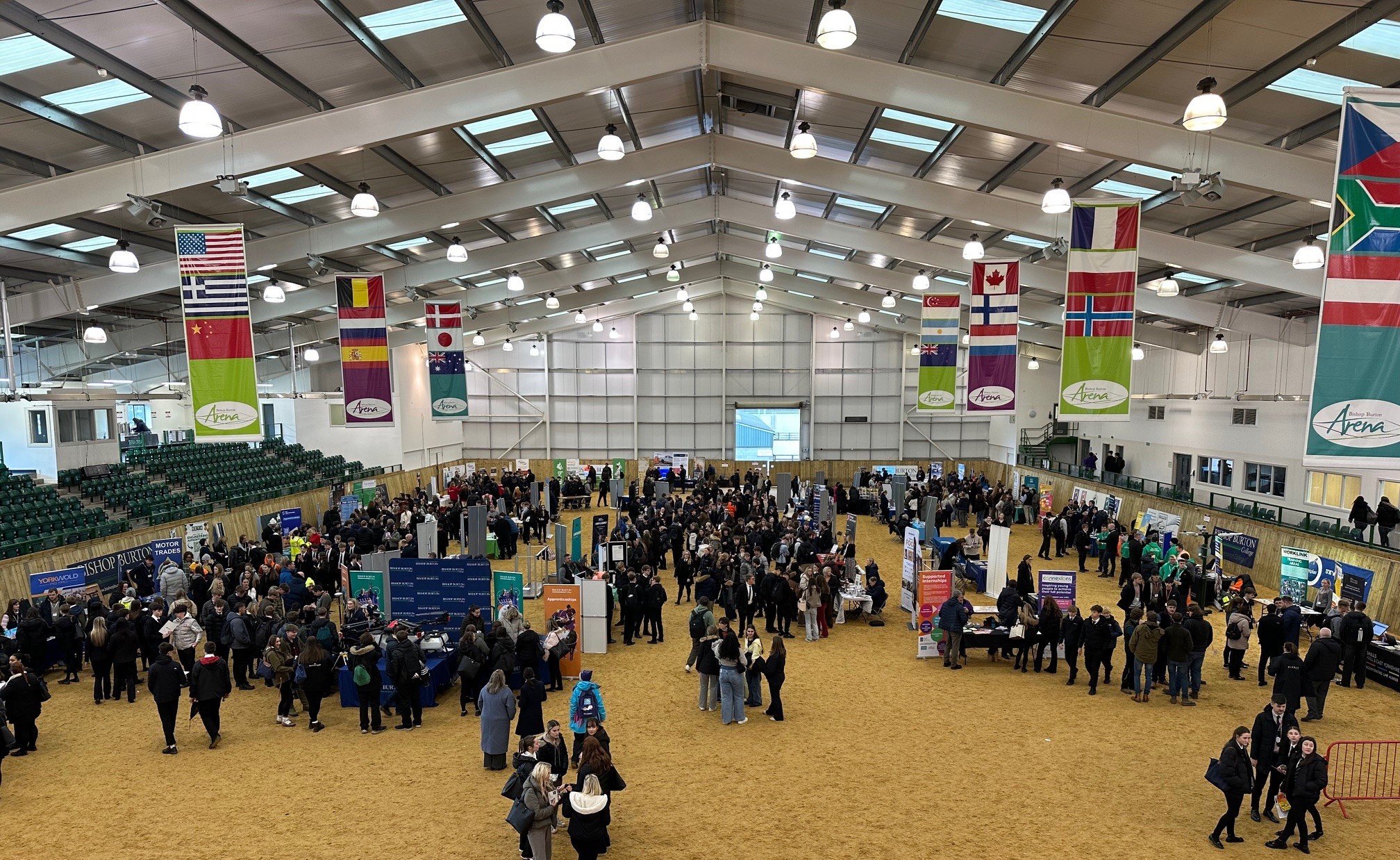 the arena from above shows lots of stands with people walking around.