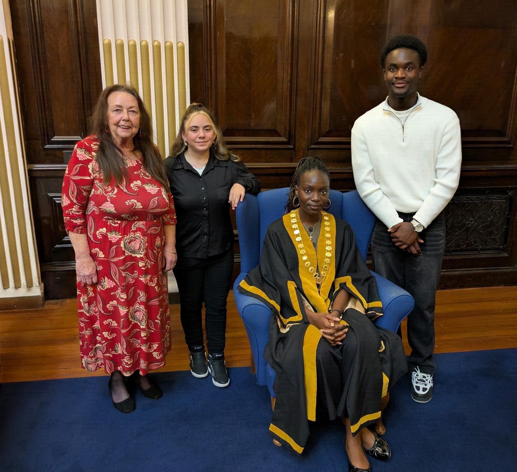 Linda Tock with the new young mayor, the previous young mayor, and the new deputy. They stand in an ornate room at the guildhall.